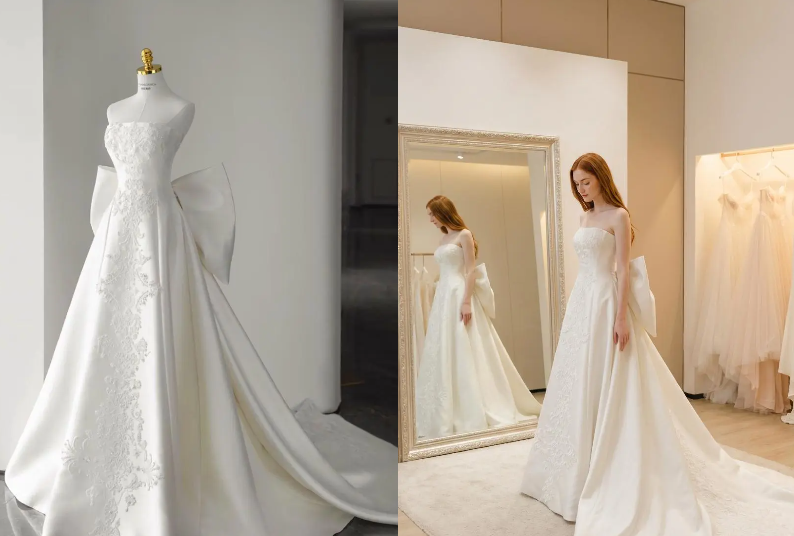 A white strapless wedding dress with exquisite embroidery and a large bow detail; the left shows the dress on a mannequin, and the right shows a model wearing it in a fitting room setting.