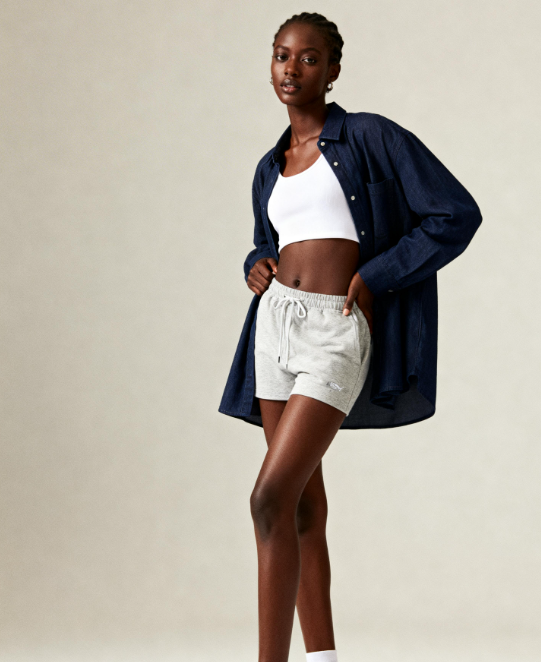 Original model photography of a navy shirt and grey shorts before AI editing.