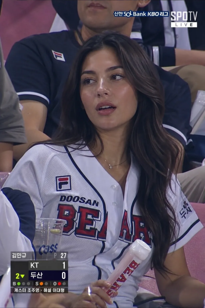 09 – WeShop AI Blog AI-generated realistic sports broadcast screenshot of a woman in a Doosan Bears jersey at a KBO game via gpt image2.