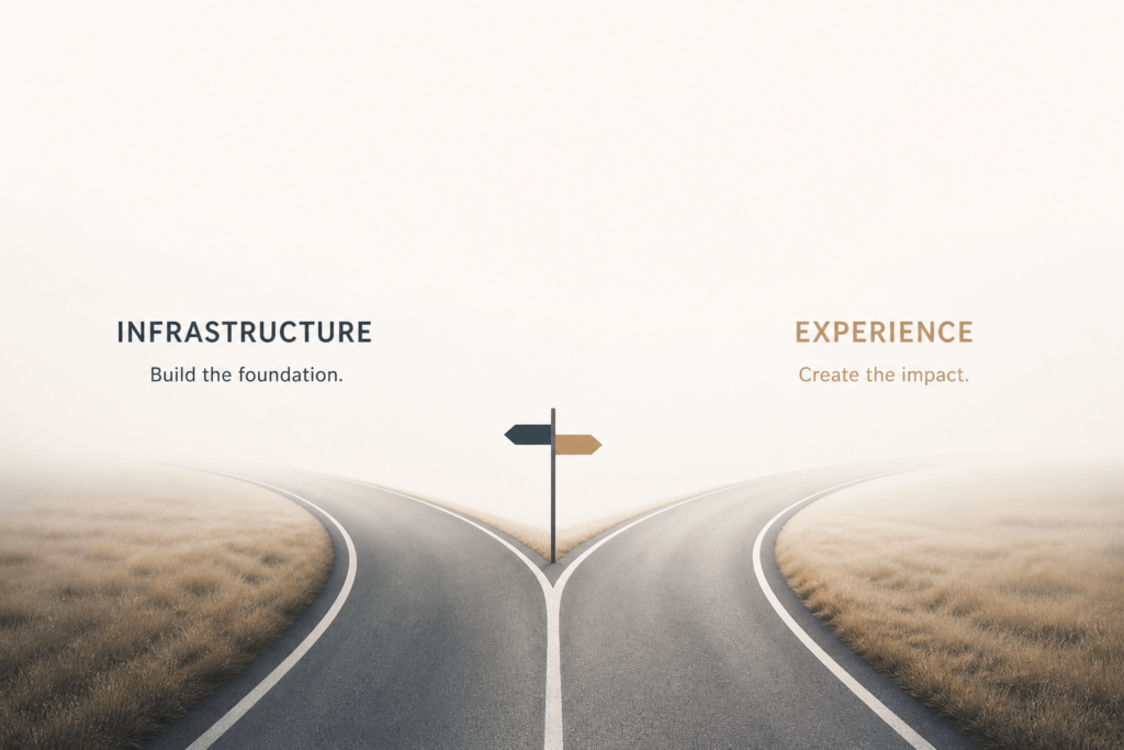 A fork in a road shrouded in mist, with signs pointing left toward "Infrastructure: Build the foundation" and right toward "Experience: Create the impact."