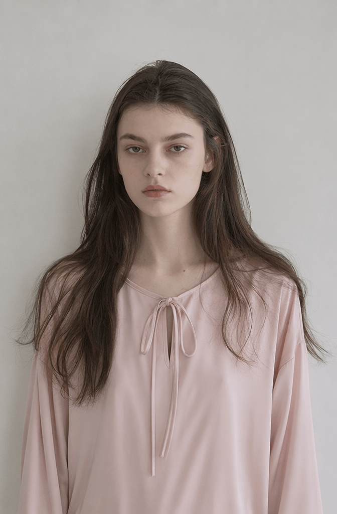 High-end editorial photography portrait generated using WeShop AI showing a female model in a light pink tie-front blouse with natural lighting.