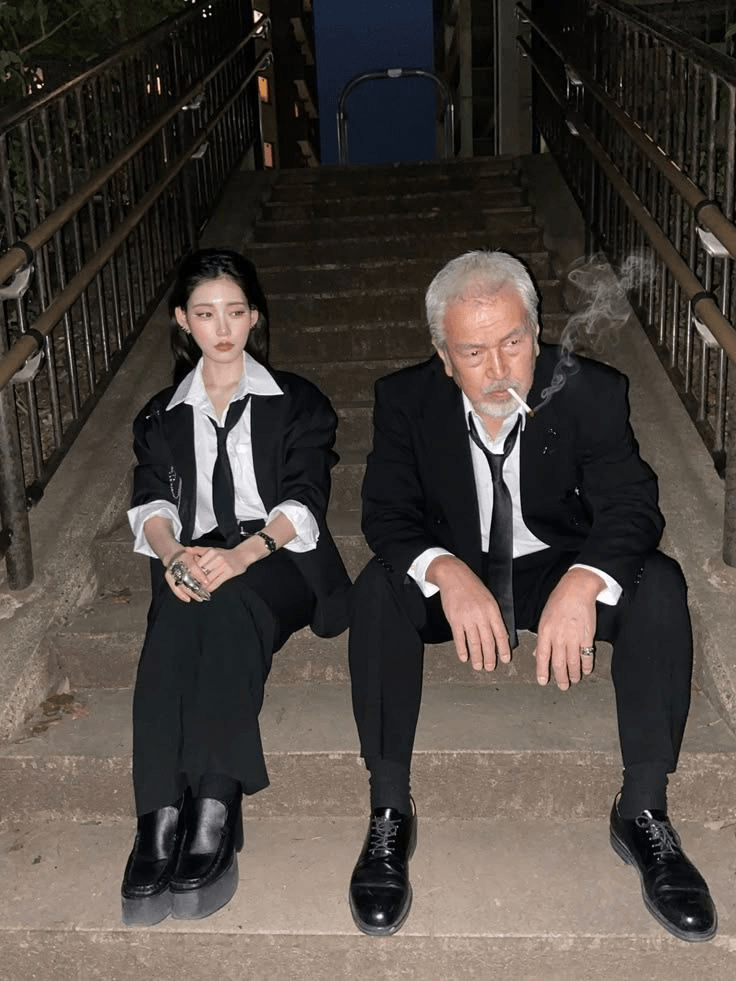 eg88 – WeShop AI Blog Original photo of two people in black suits sitting on outdoor stairs at night, used for AI image transformation.
