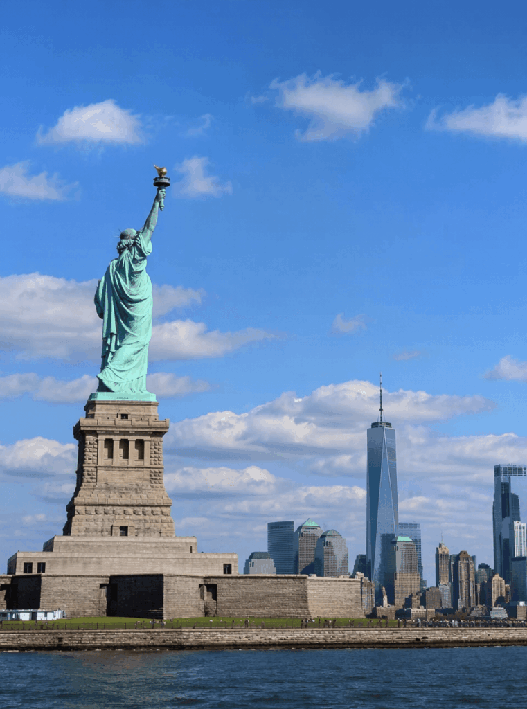 Original Statue of Liberty travel photo with blue sky and New York skyline