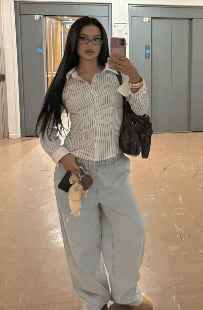 小红书 – WeShop AI Blog Original mirror outfit photo of a fashion blogger wearing a striped shirt, light blue jeans, brown slippers, glasses, and a black shoulder bag.