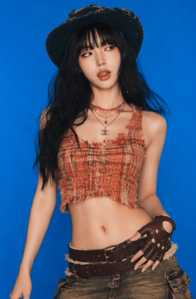 毕业4 – WeShop AI Blog Portrait reference of a woman in a black hat and orange crop top against a blue background for an AI graduation photo edit.