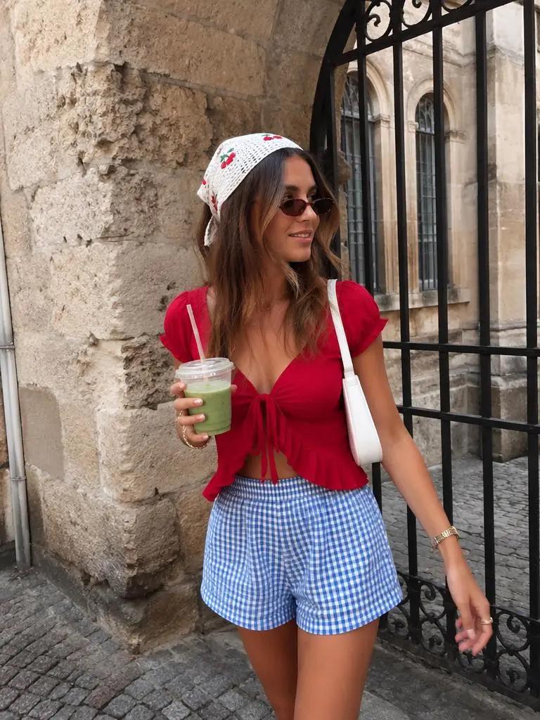 Clean outdoor outfit photo of a woman in a red top and blue shorts before using a digital camera filter online.
