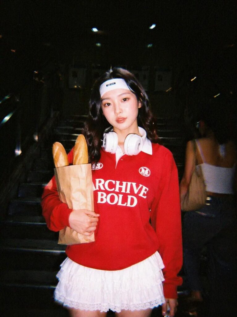Y2K digital camera edit of a woman in a red sweatshirt on dark subway stairs with flash, grain, and nostalgic night photo mood.