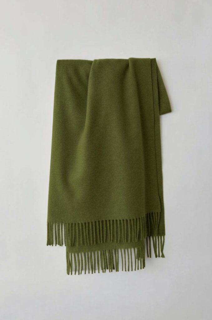 Olive green fringed scarf shown with the same folds, texture, fringe details, lighting, and background.