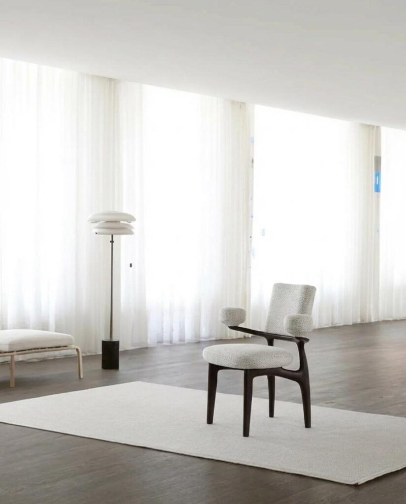 AI Image Combiner result placing the white upholstered chair naturally inside a bright minimalist living room.