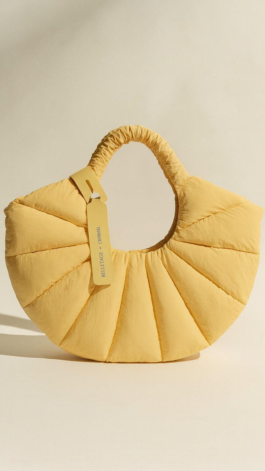 AI 360 Video Production converts a yellow sculptural handbag photo into a smooth rotating product showcase.
