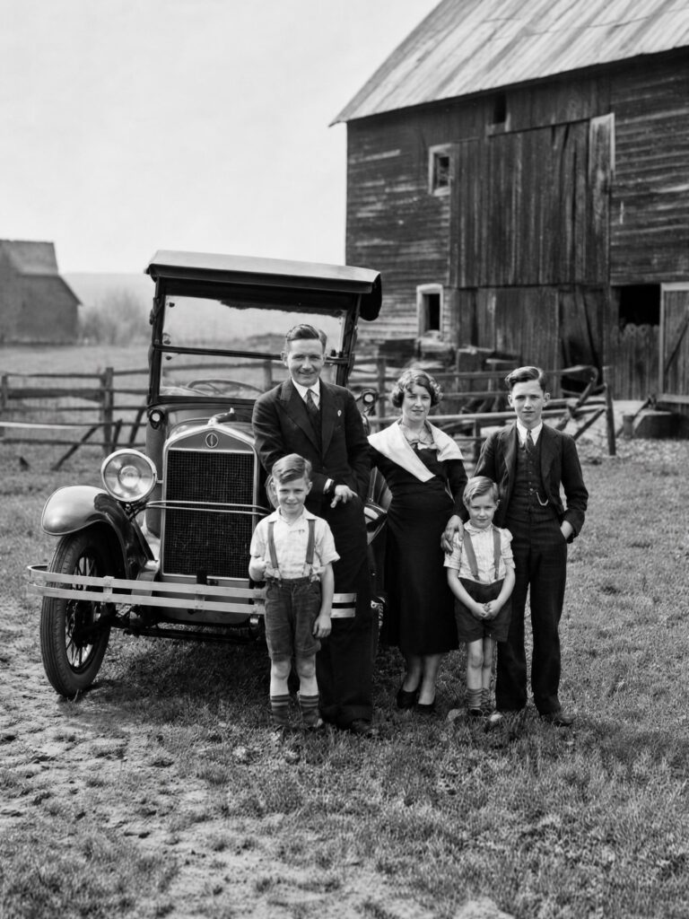 AI-restored black-and-white family photograph with removed stains, repaired damage, sharper subjects, and improved tonal contrast.