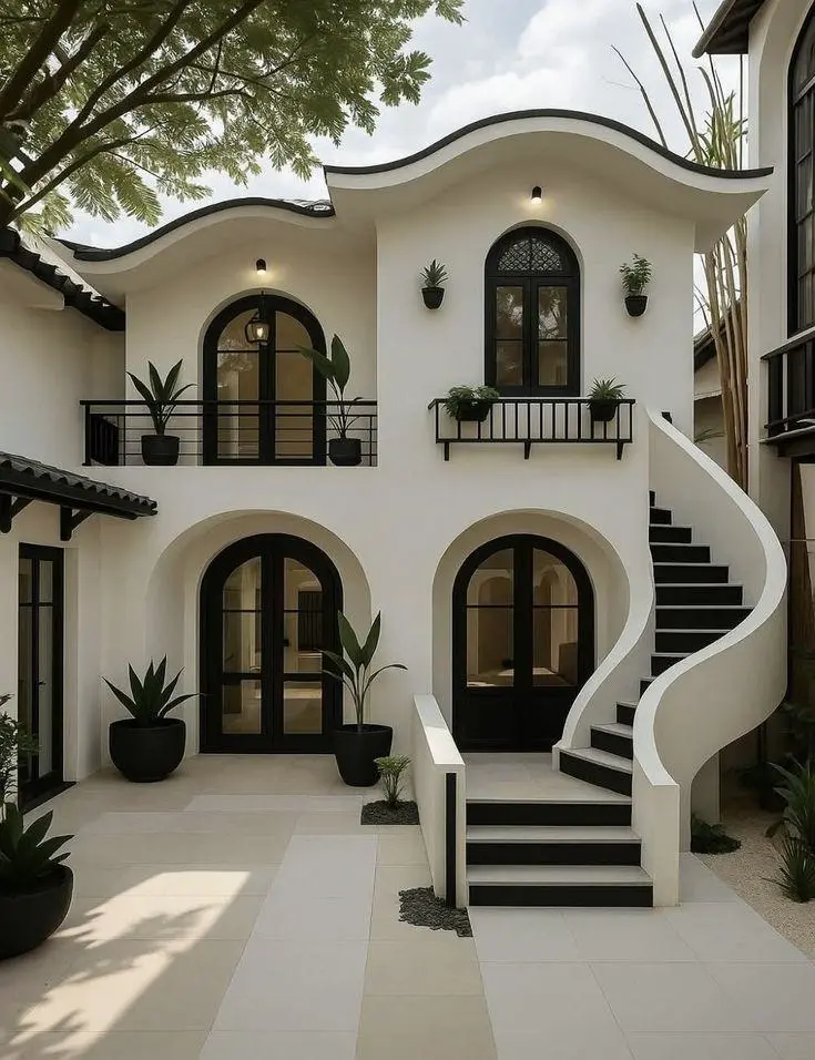 Expanded landscape view of a white courtyard house with surrounding balconies, plants, and shaded walkways.