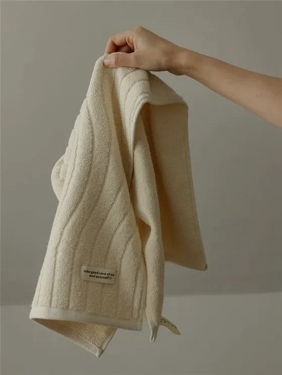 rlr – WeShop AI Blog Cream towel held by hand before AI Relight Tool lighting correction.