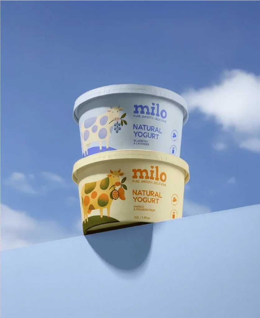 pa1 – WeShop AI Blog Two Milo natural yogurt cups in blueberry lavender and mango passion fruit designs displayed against a blue sky.